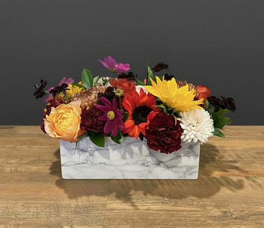 flowers sitting on a wooden table with a black background